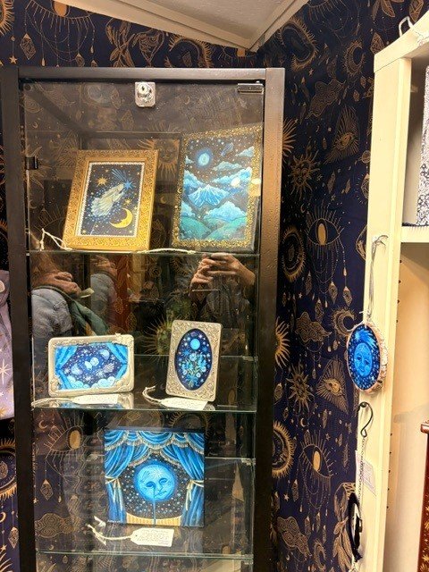 Decorative moon and handmade items displayed on shelves