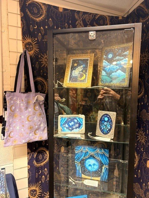 Framed celestial illustrations in a glass cabinet
