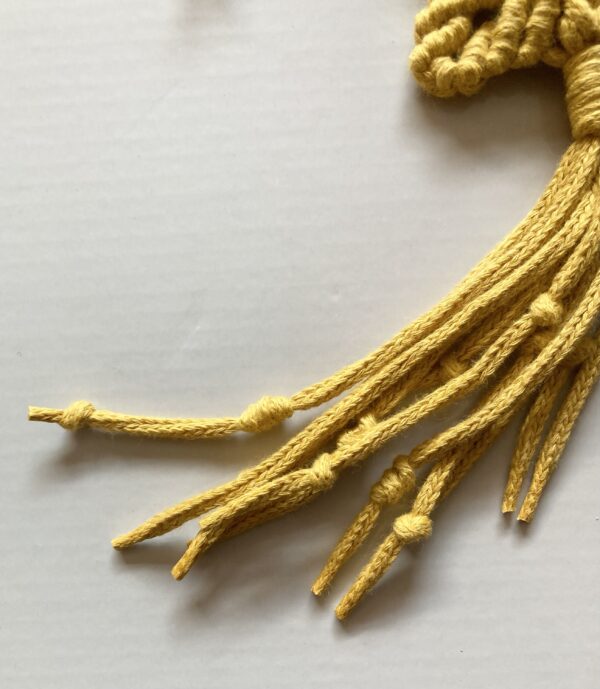 A handmade macrame star in mustard yellow cotton braided cord. - Image 4