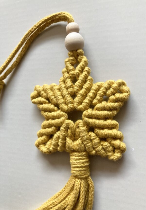 A handmade macrame star in mustard yellow cotton braided cord. - Image 2