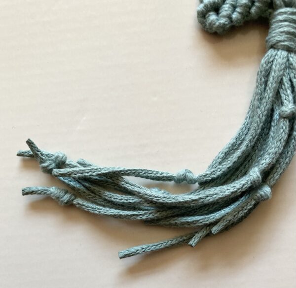 A handmade sage green macrame star. - Image 3