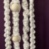 Handmade cream coloured macramé decoration with wooden beads