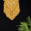 Mustard yellow wall hanging on a dowel with wooden beads