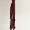 deep red macramé hanging plant holder