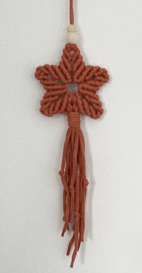 A handmade terracotta orange macrame star. - Image 5