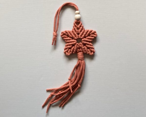 A handmade terracotta orange macrame star.